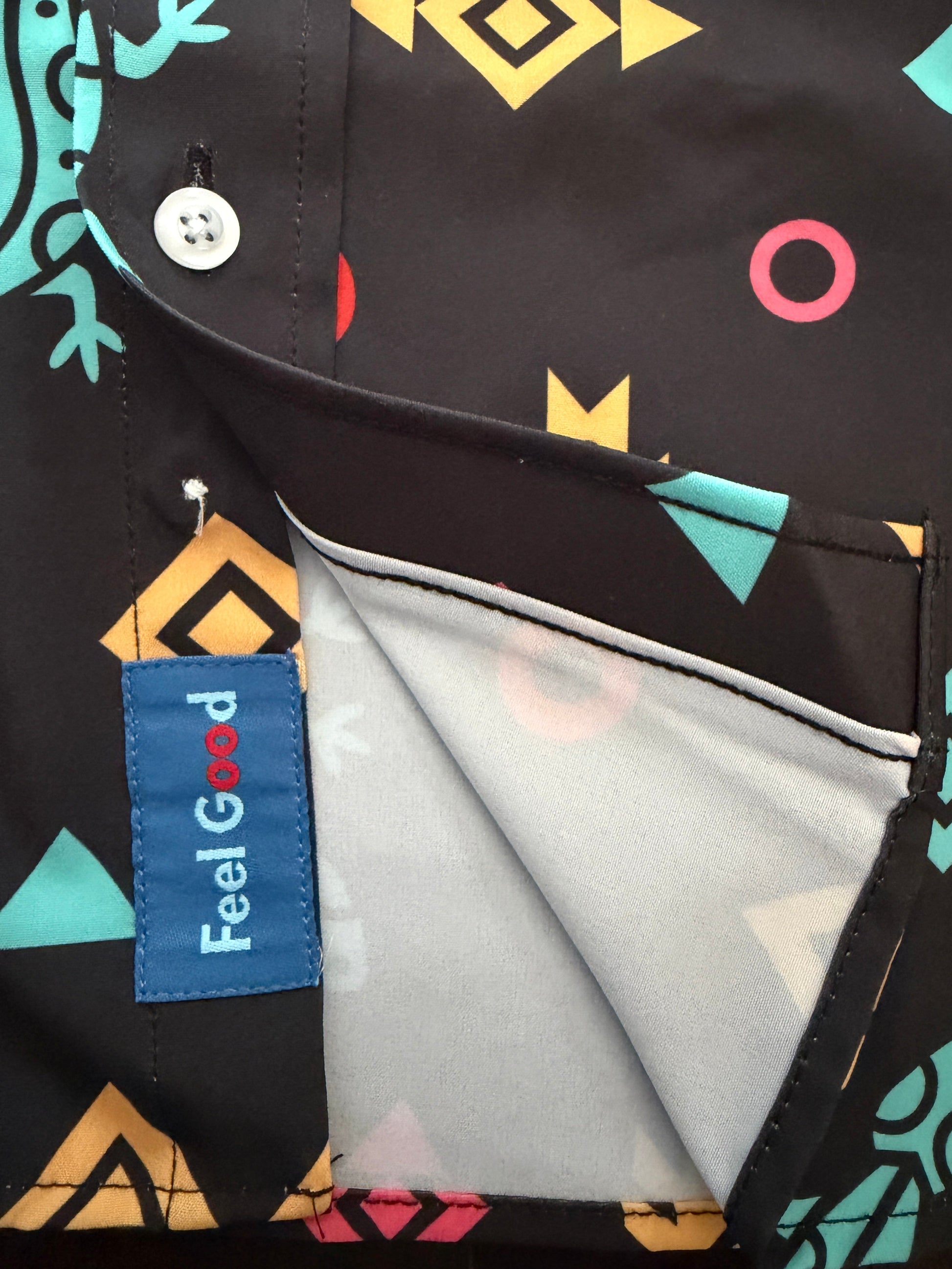 Close-up of a black button-up shirt with a colorful geometric print, featuring a blue 'Feel Good' brand label on the pocket.